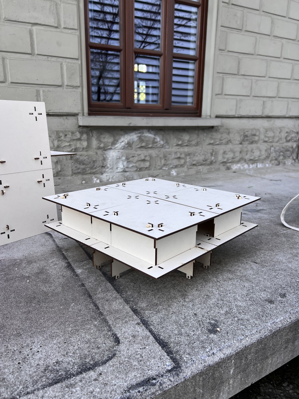 CRUX — assembled low table prototype with cross-shaped grid cutouts