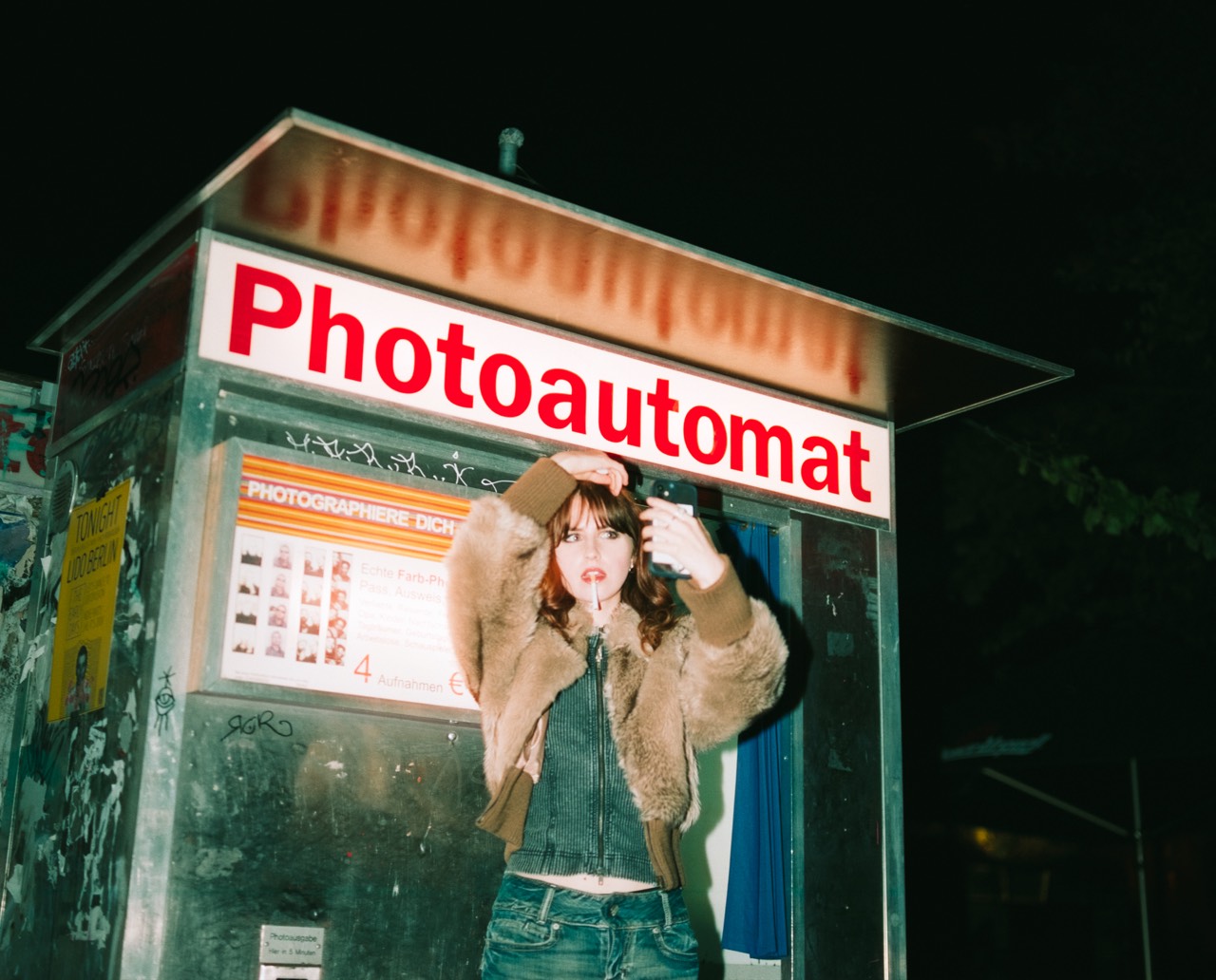 Differences — Felicitas Barth in front of a Berlin Photoautomat booth at night, on CineStill 800T; photograph by Tom Pradella