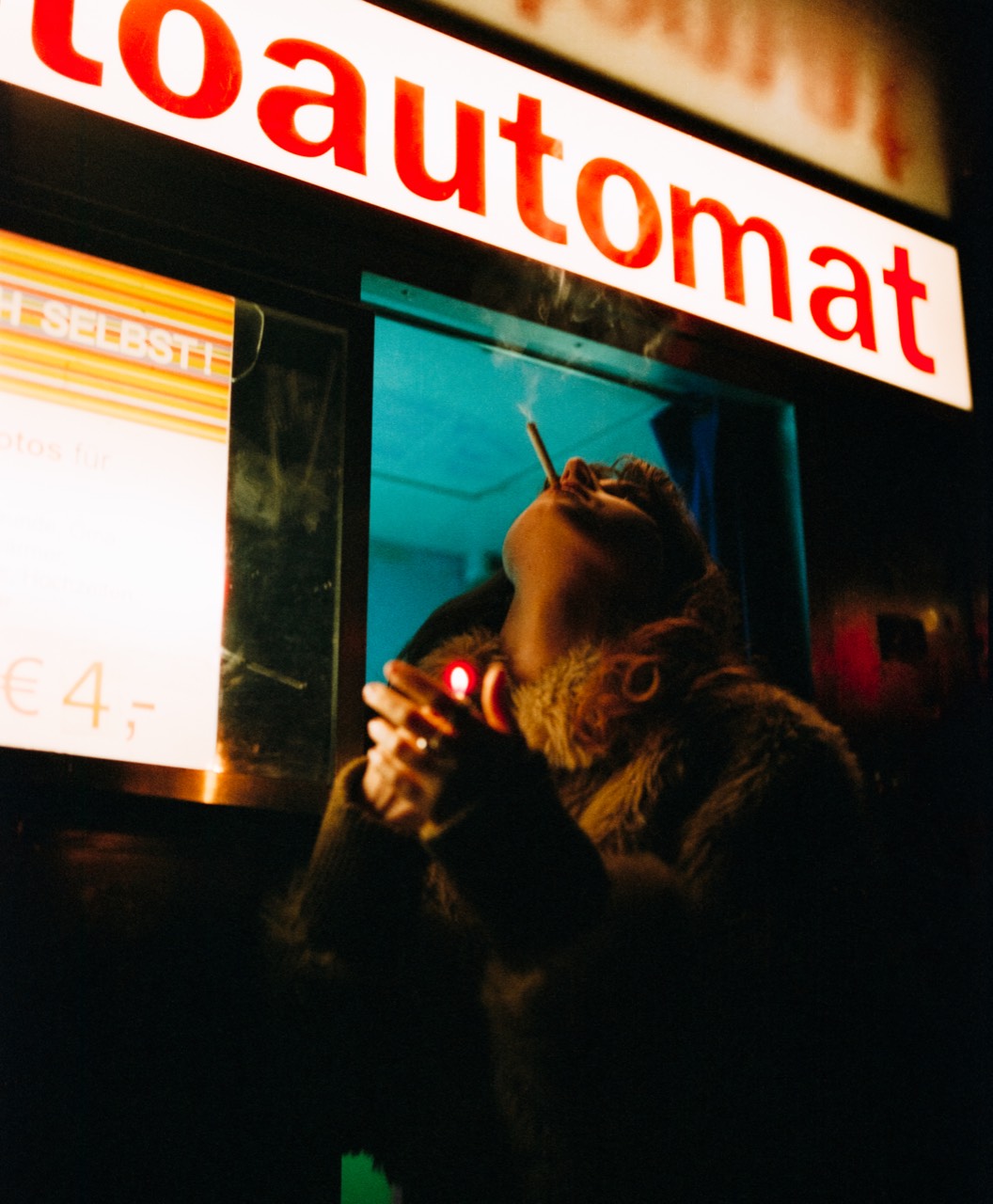 Differences — night portrait under the Photoautomat sign, on CineStill 800T