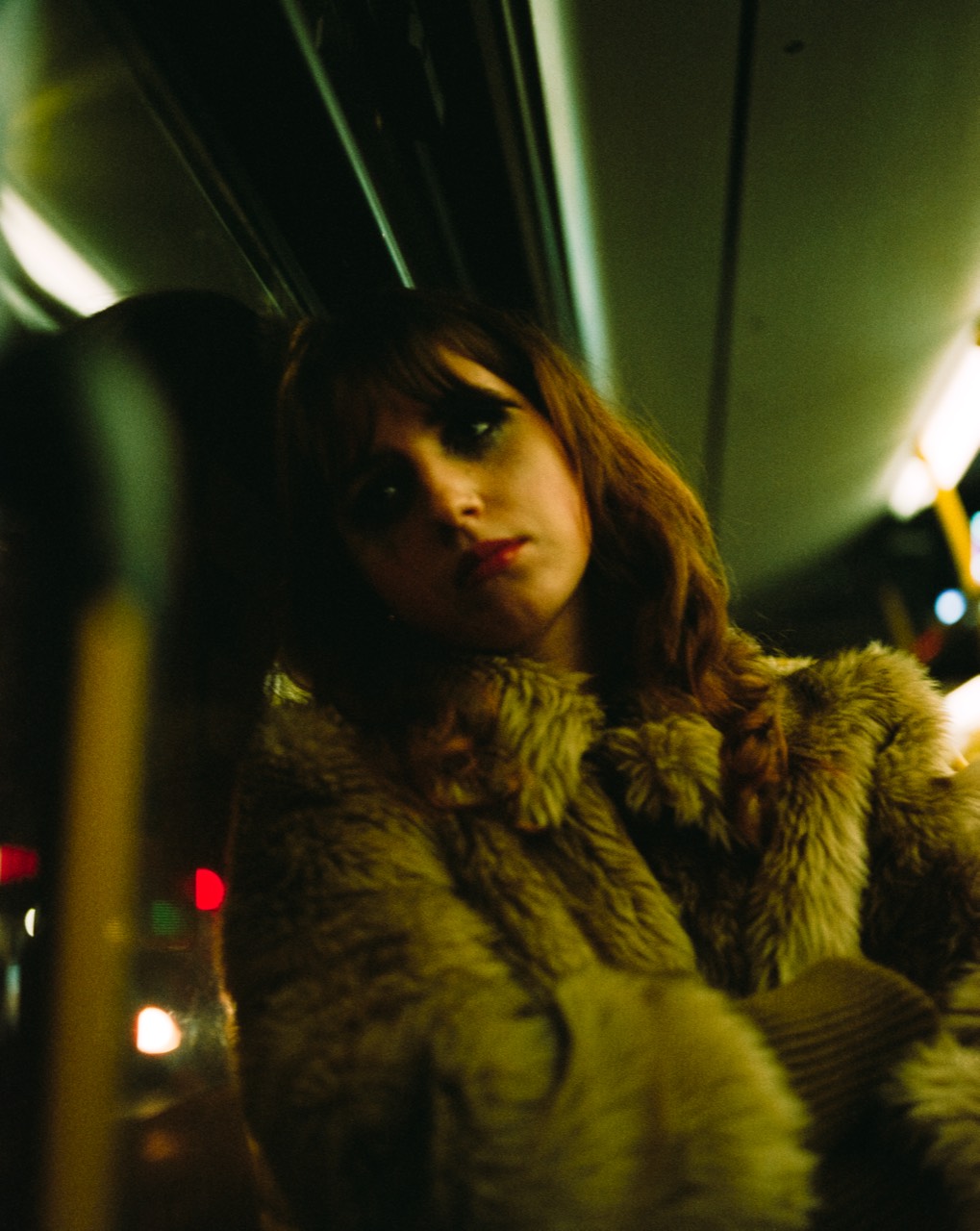 Differences — portrait in a fur coat inside a U-Bahn car, on CineStill 800T