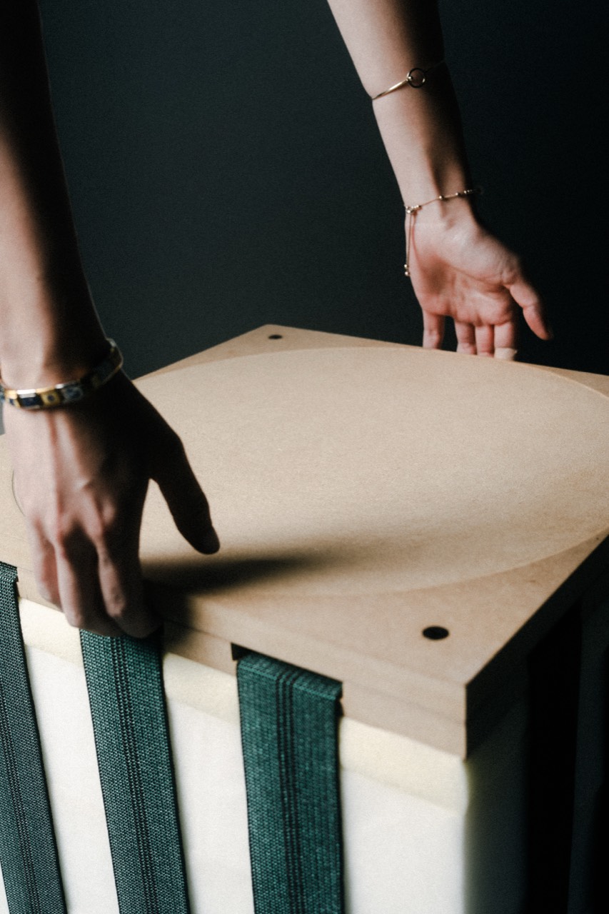 Inverso stool — hands on the wooden seating board